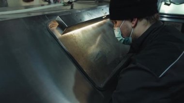 Adam koruyucu cam ekranın arkasındaki paslı metal araba ayrıntıları için yüksek basınçlı çamaşır makinesi kullanıyor.