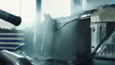 Usta, radyatörü yüksek basınçlı çamaşır makinesiyle yıkar radyatörü kirden ve böceklerden temizler.