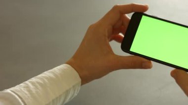 Adamın elinde yüksek çözünürlüklü yeşil ekran cep telefonu var. Yüksek kaliteli FullHD görüntüler
