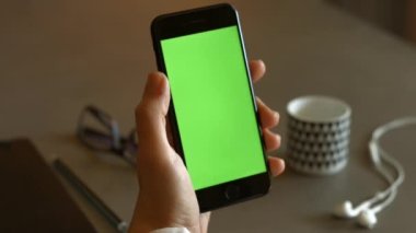Kullanıcı elinde yeşil ekranlı akıllı telefon tutuyor. Yüksek kaliteli FullHD görüntüler