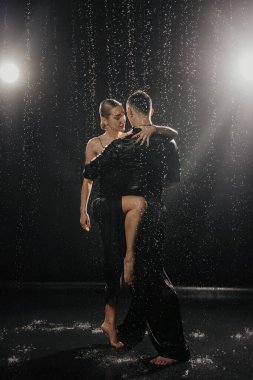 A couple of dancers on a black background in a studio in the aqua zone. High quality photo