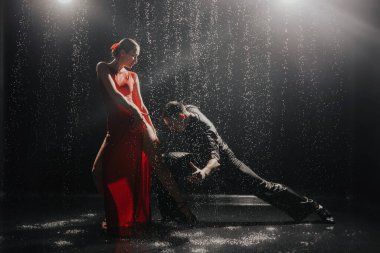 A couple of dancers on a black background in a studio in the aqua zone. High quality photo