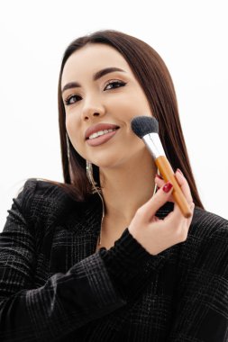Makeup artist girl holding makeup brushes near her face . High quality photo