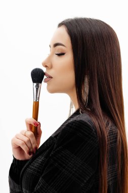 Makeup artist girl holding makeup brushes near her face . High quality photo