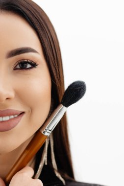 Makeup artist girl holding makeup brushes near her face . High quality photo
