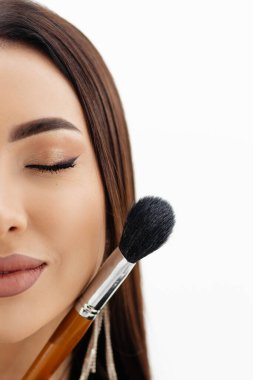 Makeup artist girl holding makeup brushes near her face . High quality photo