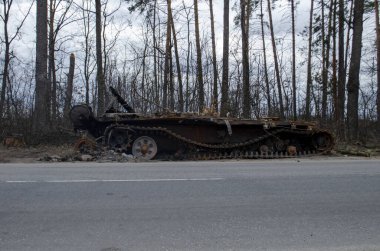 Ukrayna 'da savaş. Yolun kenarında hasarlı ve yanmış bir Rus tankı..