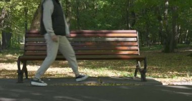 Genç bir kız bankta oturur, telefonunu çıkarır ve mesajları okur. Ön görünüm