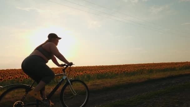 Överviktig Ung Kvinna Cyklar Landsbygden Vid Solnedgången För Att Ner — Stockvideo