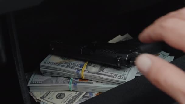 隠された拳銃と車のグローブボックスコンパートメントから多額のお金を引き出す男性を閉じる — ストック動画