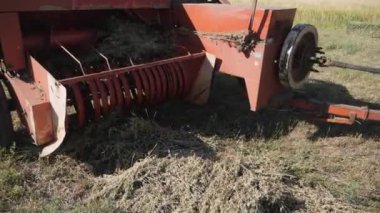 1960 'lar: Bar balya biriktirici makinede balyaları yana doğru itiyor. Traktör arkasında balyalar olan akümülatörü çeker. Traktör ve akümülatör, balyalar yerine yerleştirilirken....