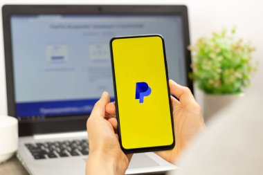 Kyiv, Ukrayna - 15 Ekim 2022: Faturaları ödemek ve internetten mal satın almak, para transferleri ve dizüstü bilgisayar alışverişi için kullanılan akıllı bir telefonun ekranında PayPal. E-ticaret.