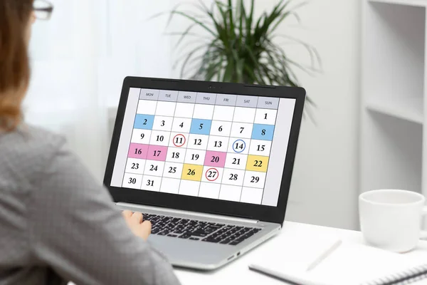 ラップトップでカレンダーを使用して毎月のビジネスミーティング スケジュール 目標を計画する女性 ストック写真