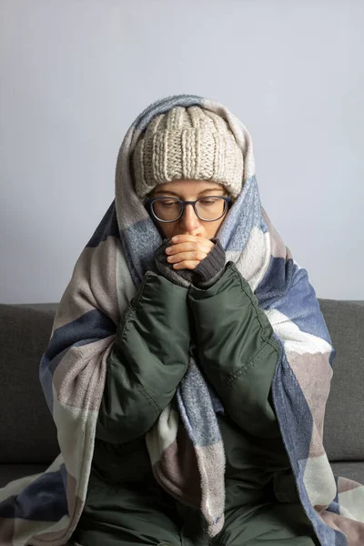 Uma Mulher Envolta Cobertor Aquece Enquanto Está Sentada Uma Sala — Fotografia de Stock