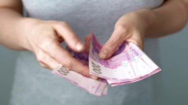 Ukrayna parası. 200 Hryvnia banknotlarını sayan bir kadın. Yakın plan..