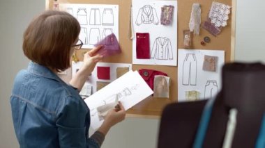 Woman fashion designer with sketches in the studio. Seamstress at work.