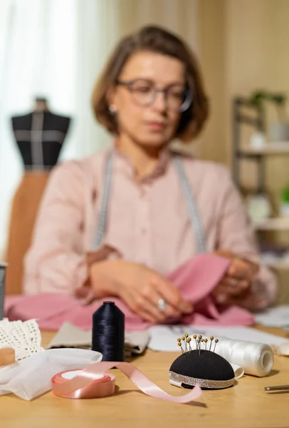 テーブルの上で服のスケッチに取り組む女性ファッションデザイナー ストックフォト