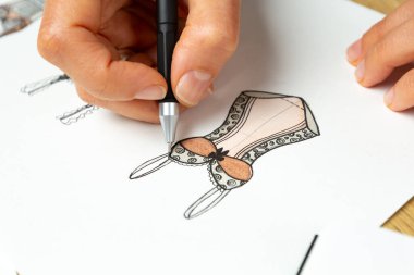 Tasarımcı kadın iç çamaşırı taslakları çiziyor. Kağıt üzerinde iç çamaşırı ve sutyen..