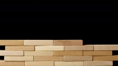 Bir el duvara ahşap bir taş yerleştirir. İş dünyasındaki proje planlama kavramı. İnşaat ve risk.