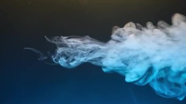 Kıvırcık duman renkli bir arka planda hareket eder. Soyut duman çizgileri. Neon arkaplanda dumanın canlandırması