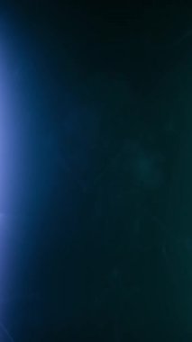 Dikey video. Kıvırcık duman renkli bir arka planda hareket eder. Soyut duman çizgileri. Neon arkaplanda dumanın canlandırması