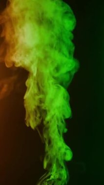 Dikey video. Kıvırcık duman renkli bir arka planda hareket eder. Soyut duman çizgileri. Neon arkaplanda dumanın canlandırması