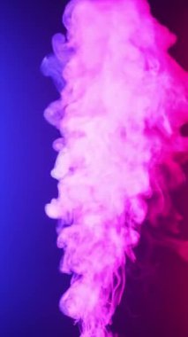Dikey video. Kıvırcık duman renkli bir arka planda hareket eder. Soyut duman çizgileri. Neon arkaplanda dumanın canlandırması