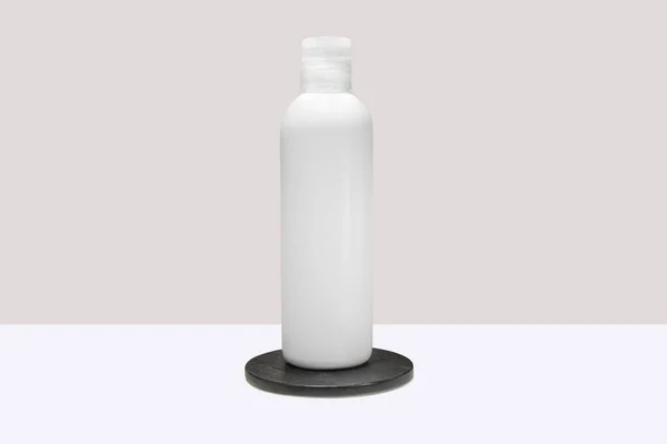温泉洗发水 淋浴露 黑色讲台上的液体肥皂的白色瓶子模型 — 图库照片