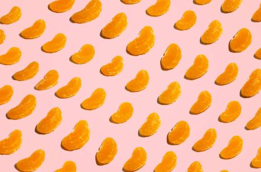 Pembe arka planda portakal dilimlerinin üst görüntüsü. düz alan, kopyala boşluk, desen.