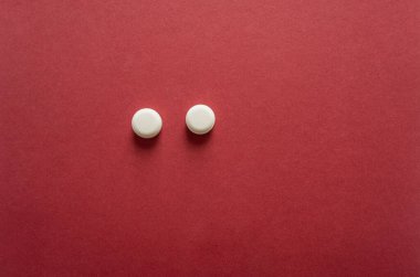Kırmızı arka planda izole edilmiş tıbbi haplı beyaz hap. Kopyalama alanı olan asgari tıp kavramı.