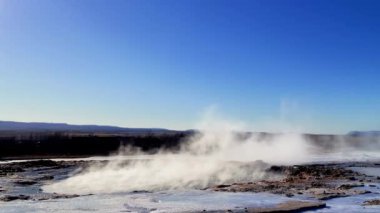 İzlanda. Gayzer Strokkur 'u patlatıyor. Strokkur jeotermal alanın bir parçasıdır. Yerden duman tütüyor. Dünyadaki en güzel yerler..