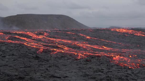 火山喷发 大自然的奇迹 地底喷出炽热的红色熔岩 无人机飞越活火山火山口熔岩在黑暗的岩石中流动 表面凝固并破裂 — 图库视频影像