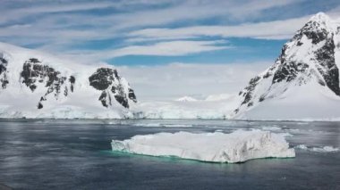 Antarktika. Buzdağları. Küresel ısınma ve iklim değişikliği. Güzel doğa. Karlı dağların ve buzlu kıyıların manzarası. Ayna yansıması açık okyanusta yüzen güzel mavi buzdağı. Buzullar