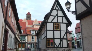 Quedlinburg, Almanya - 23 Ağustos 2023: Alman geleneksel mimarisi yarı keresteli evler. Eski bir Alman küçük turist kasabasının yarı keresteli ortaçağ sokakları. Ortaçağ şehri. Seyahat et. Wernigerode.