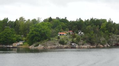 Kıyıdaki kulübeler. İsveç. Rocky Adası 'ndaki İsveç Ahşap Kulübesi. Stockholm Takımadaları 'nın küçük adalarında güzel evler ve tatil evleri.