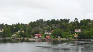 Kıyıdaki kulübeler. İsveç. Rocky Adası 'ndaki İsveç Ahşap Kulübesi. Stockholm Takımadaları 'nın küçük adalarında güzel evler ve tatil evleri.