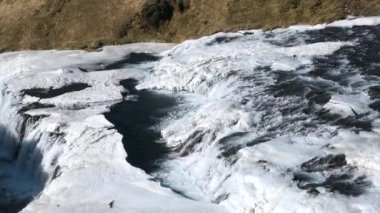 Doğa. Kış. Kışın donmuş şelale, kar ve buzun büyülü bir yeri, saf buzul suyu. İzlanda 'nın ünlü şelalesi, Kışın güçlü kristal mavi suların güzel manzarası.