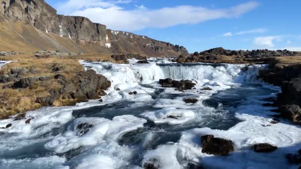 大自然 寒冷的瀑布在冬天 一个神奇的冬雪和冰的位置 纯净的冰水 冰岛著名的瀑布 美丽的景色 冬季的碧水湍急的溪流 — 图库视频影像