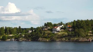 İsveç. Idyllic Stockholm takımadaları. Rocky Adası 'ndaki İsveç Ahşap Kulübesi. Geleneksel kırmızı yazlık evler. Stockholm Takımadaları. Sahilde kulübeler ve saunalar