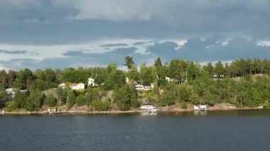 İsveç. Idyllic Stockholm takımadaları. Rocky Adası 'ndaki İsveç Ahşap Kulübesi. Geleneksel kırmızı yazlık evler. Stockholm Takımadaları. Sahilde kulübeler ve saunalar