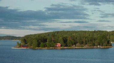 Stockholm Takımadaları. İsveç takımadaları yazın güneşli bir günde. Sahildeki yeşil orman ağaçları. İsveç doğası. Stockholm takımadalarındaki adadaki orman, Baltık Denizi