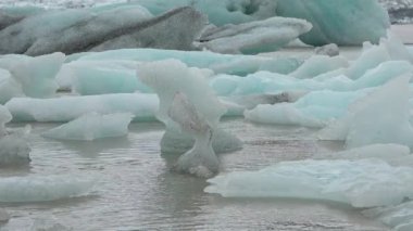 Buzdağları ve küresel ısınma. Buzdağları turkuaz okyanus koyunda eriyor. Kutup doğal ortamında buzul. Kuzey Kutbu kış manzarası ve küresel ısınma sorunu. İzlanda manzarası. Ekoloji ve iklim değişikliği.