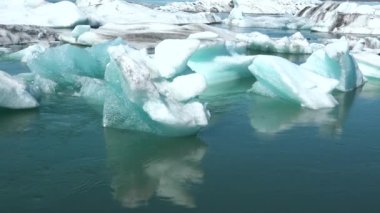Buzdağları ve küresel ısınma. Buzdağları turkuaz okyanus koyunda eriyor. Kutup doğal ortamında buzul. Kuzey Kutbu kış manzarası ve küresel ısınma sorunu. İzlanda manzarası. Ekoloji ve iklim değişikliği.