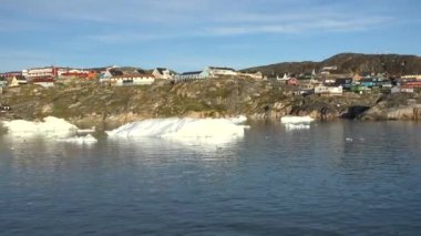 Okyanus, buzdağları ve Grönland yerleşkesi. Grönland Arktik Köyü Ilulissat. Renkli Eskimo evleri. Grönland kutup manzarası. Kuzey Kutup Dairesi 'ne git. İklim değişikliği, küresel ısınma.