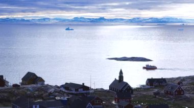 Okyanus, buzdağları ve Grönland yerleşkesi. Grönland Arktik Köyü Ilulissat. Renkli Eskimo evleri. Grönland kutup manzarası. Kuzey Kutup Dairesi 'ne git. İklim değişikliği, küresel ısınma.