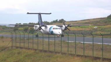 Pistte bir uçak. Atlantik Okyanusu 'ndaki bir adada havaalanı. Azores takımadalarındaki havaalanı. Sata Air Azores Havaalanı Corvo Adası 'ndan kalkıyor. Geliş, gidiş..