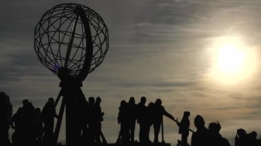 Renkli Bulutlar ve Globe Anıtı 'nın Silueti ve insanlarla Sunset' te Nordkapp. Gece yarısı Kuzey Burnu 'nda, Mageroya, Norveç' teki dünya anıtı.