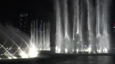 Dubai Çeşmesi Su Şelalesi 'nin gece vakti dans eden çeşmesinin manzarası. Dubai alışveriş merkezinde lazer ışığı, Burj Halife binası yakınlarında..