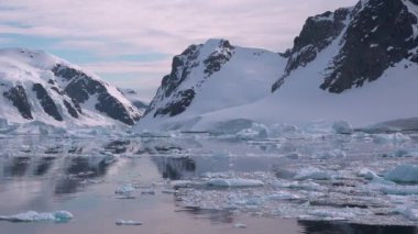 Buz dağının parçalarını okyanusta eritmek. Kocaman bir Buzul Parçası. Buzullar dünyanın kuzey çemberinde eriyor. Kutup buzulu. Antarktika dağ manzarası. Ekoloji problemi, küresel ısınma. Çevre.