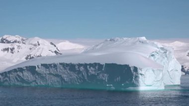 Buz dağının parçalarını okyanusta eritmek. Kocaman bir Buzul Parçası. Buzullar dünyanın kuzey çemberinde eriyor. Kutup buzulu. Antarktika dağ manzarası. Ekoloji problemi, küresel ısınma. Çevre.